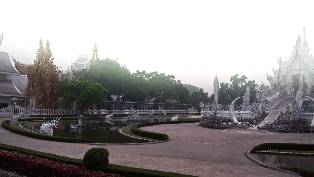 Ornate white temple of Wat Rong Khun with elaborate carvings in haze