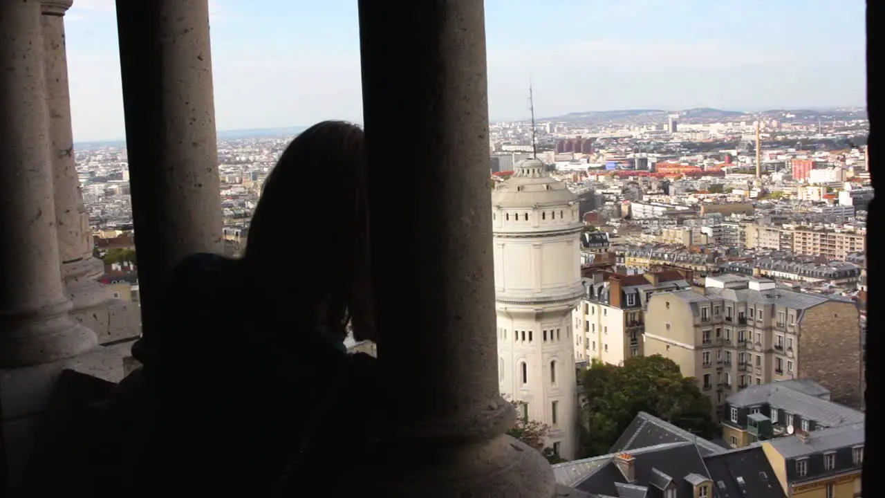 Blonde girl looking at the Bell Tower of the Basilica of the Sacred Heart in Montmartre Paris