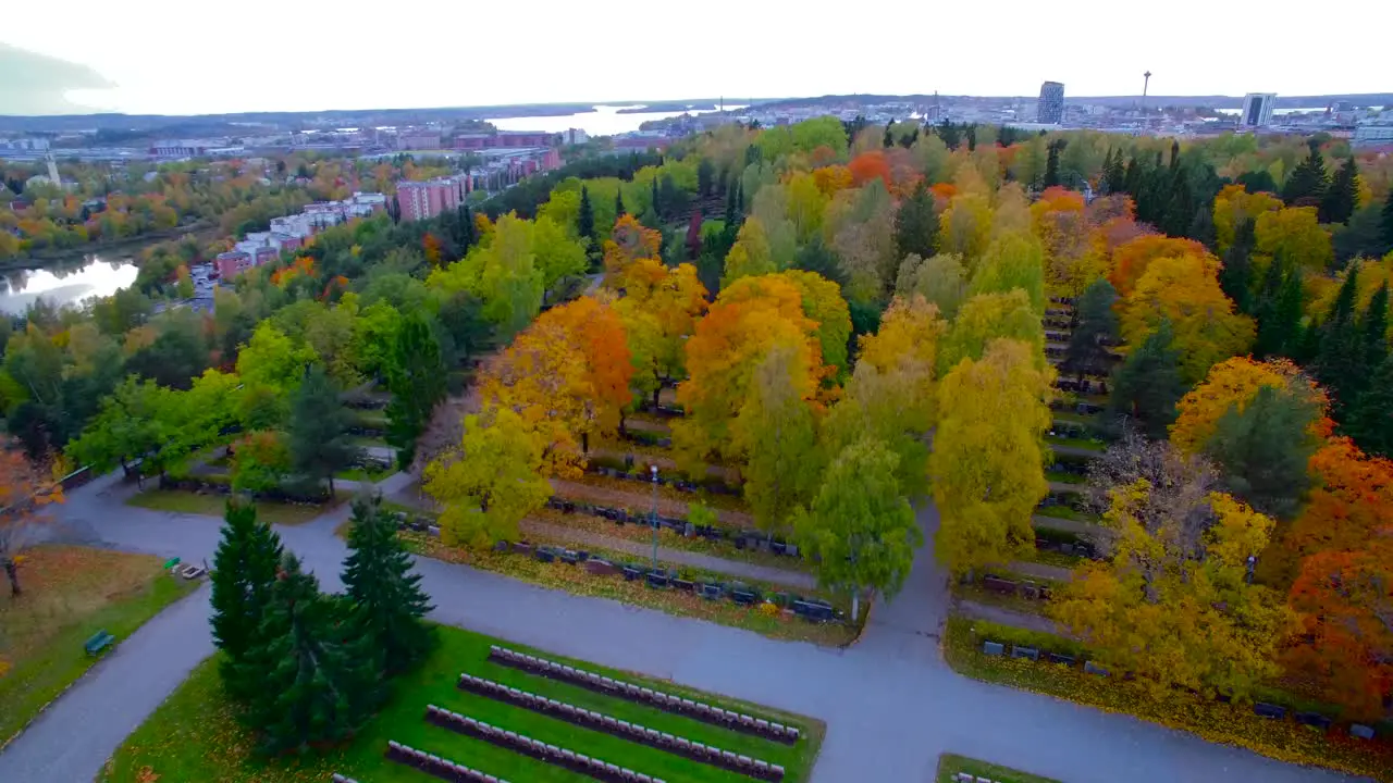 Drone rising over a cemetary showing the cityscape of Tampere in Finland