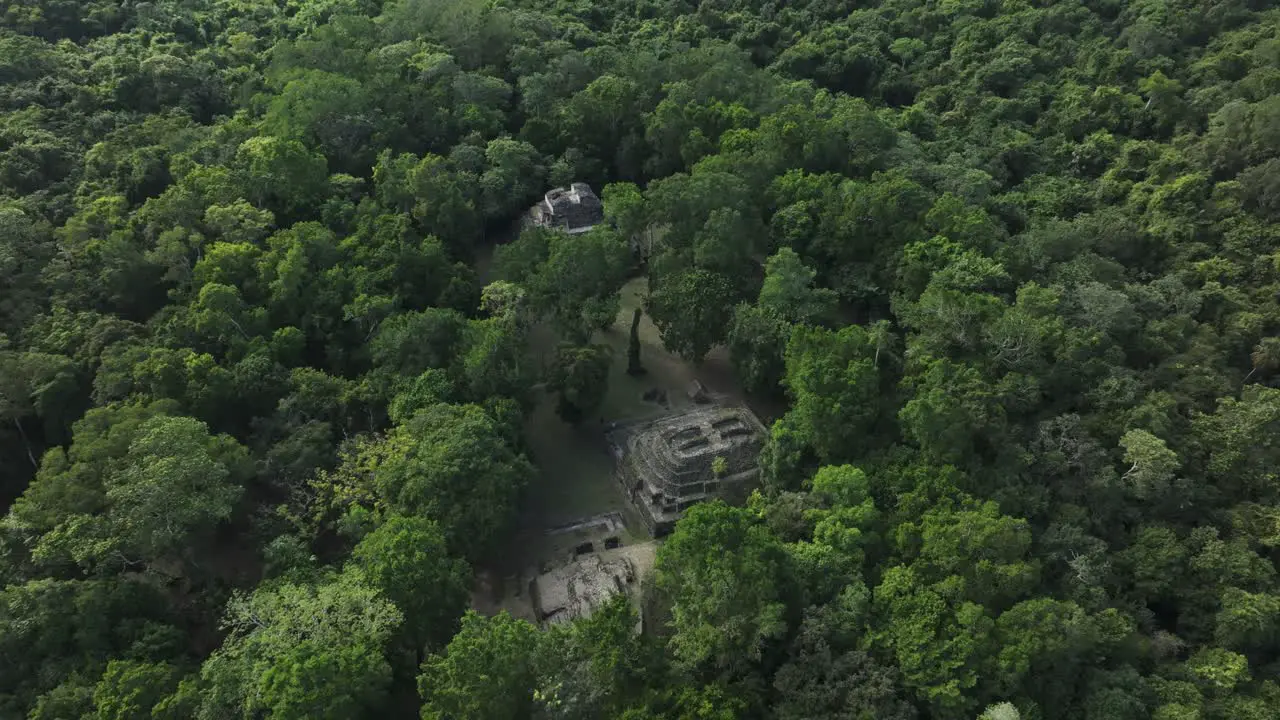 Flying backwards at Yaxha Mayan Ruins at Guatemala jungle aerial