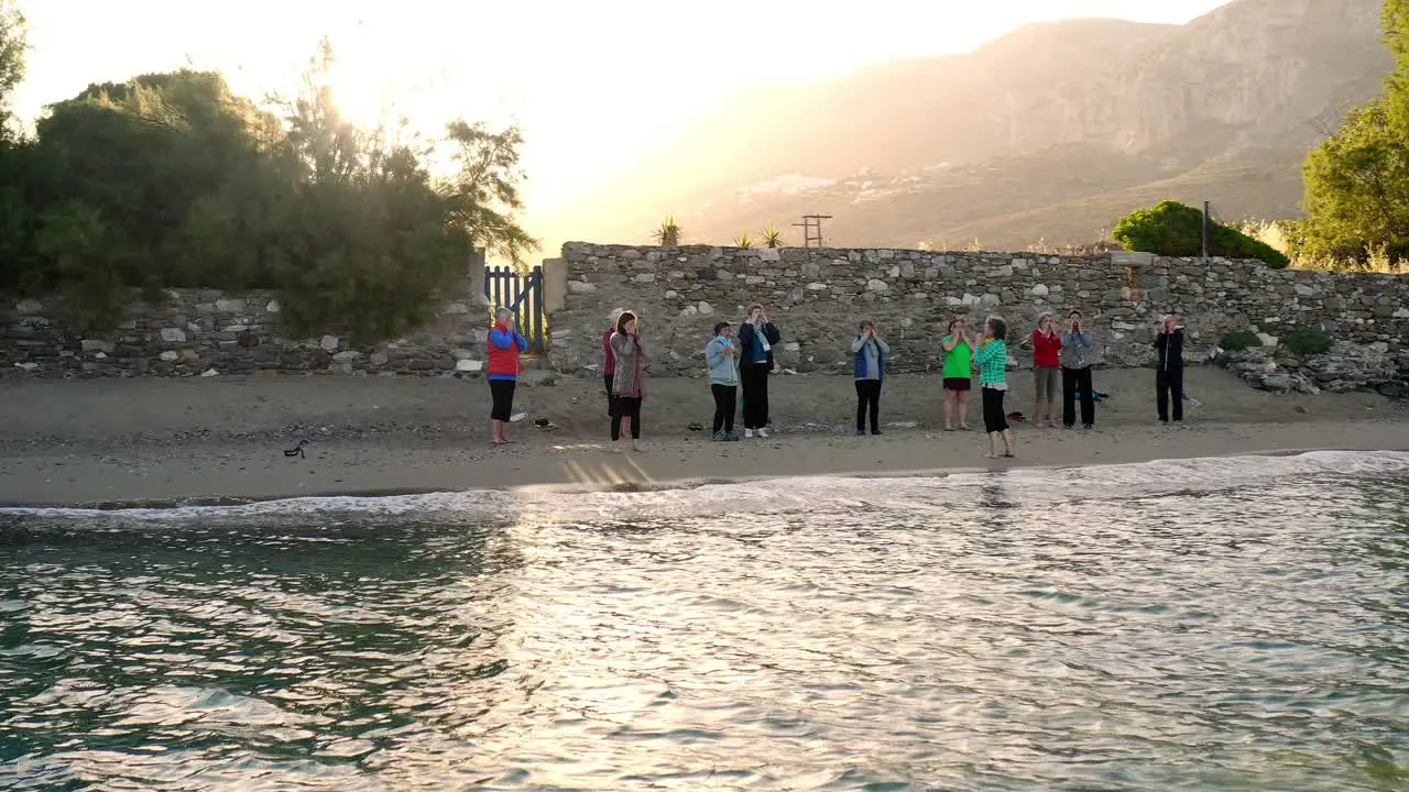 A Group Of People doing Yoga On Picturesque Beach 4K Aerial