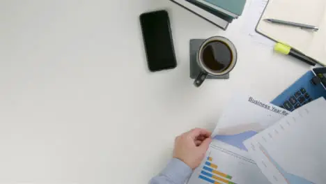 Businessman Looking Through Documents at Desk