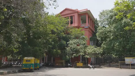 Exterior Of Traditional Pink Building In Bangalore India With Auto Rickshaw Taxi Parked In Front