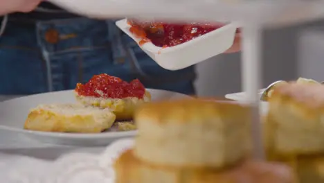 Close Up Shot Of Person With Traditional British Afternoon Tea With Scones Cream And Jam 1