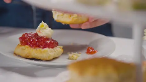 Close Up Shot Of Person With Traditional British Afternoon Tea With Scones Cream And Jam 3