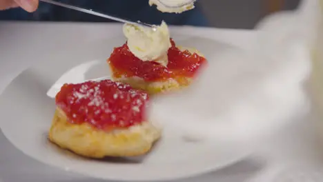 Close Up Shot Of Person With Traditional British Afternoon Tea With Scones Cream And Jam 2