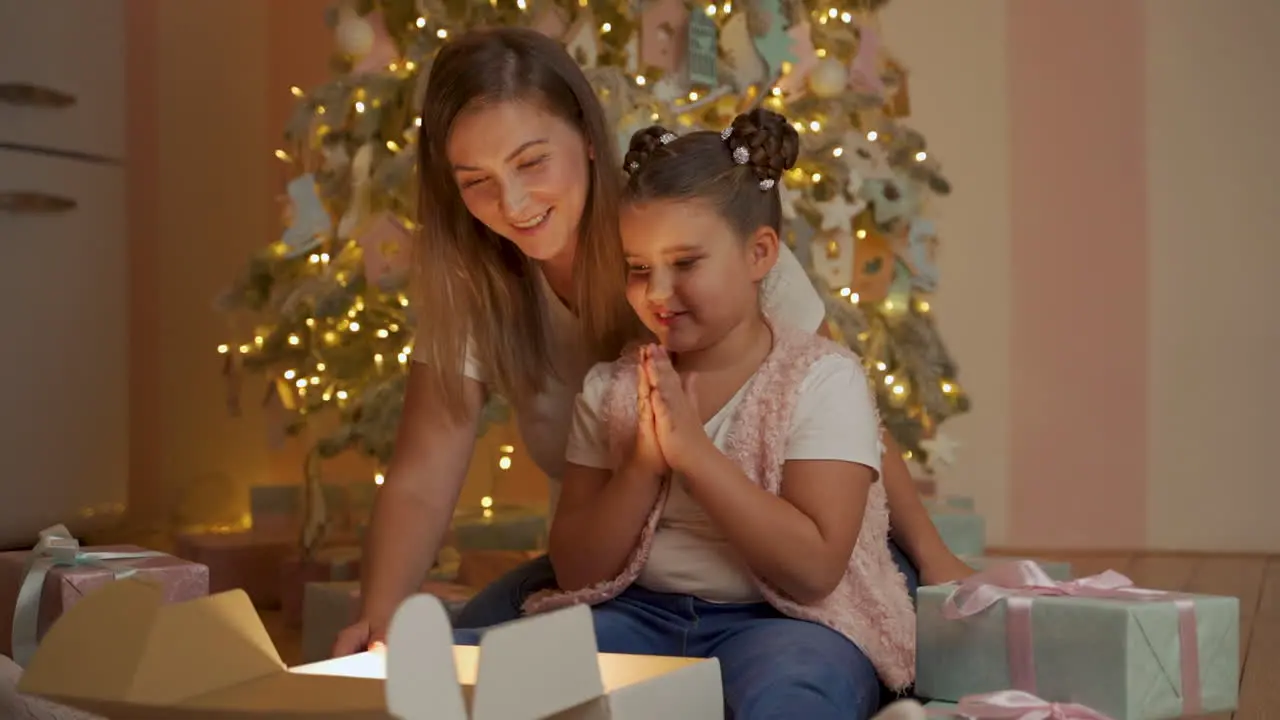 Little Girl And Woman Open Gift Box Golden Light Comes Out They Are Surprised