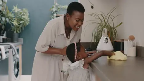 Black woman mother and child learning cleaning