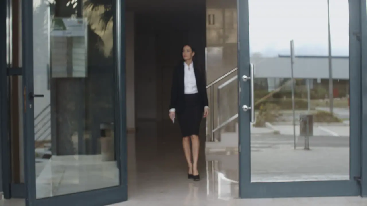 Young businesswoman exiting a modern office