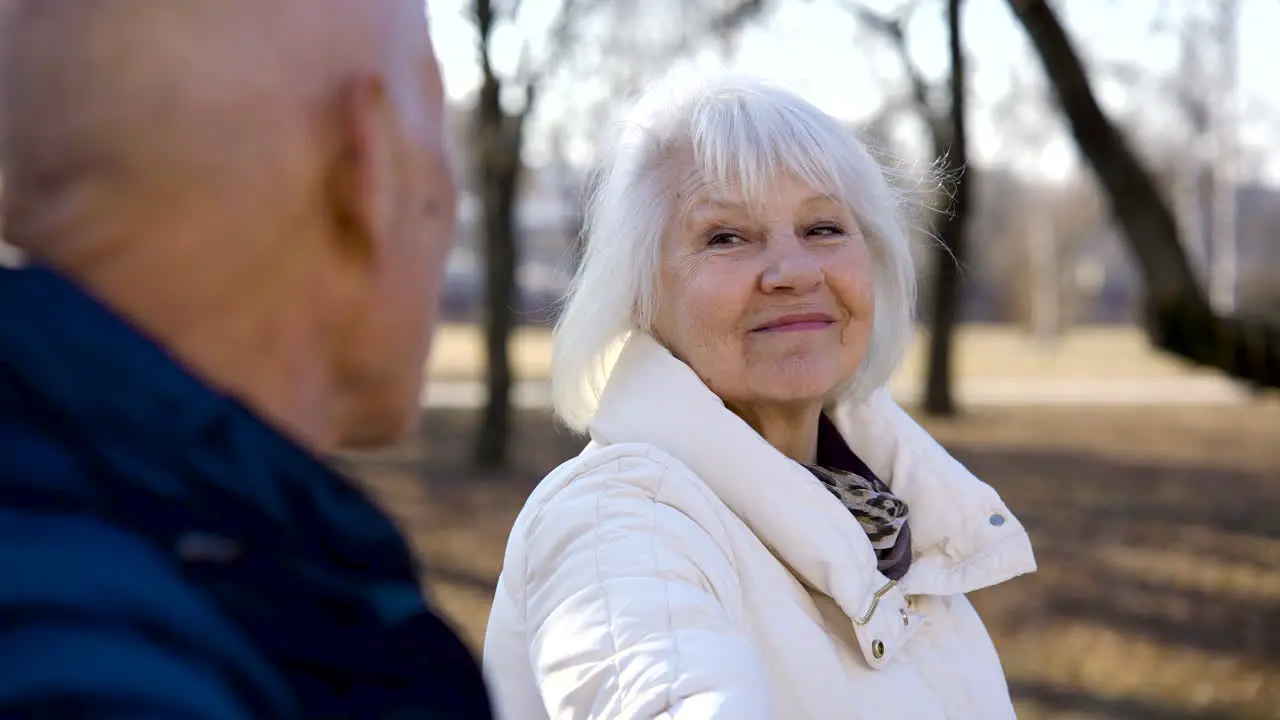 Vista Cercana De Una Anciana Hablando Con Su Esposo En El Parque En Un Día De Invierno