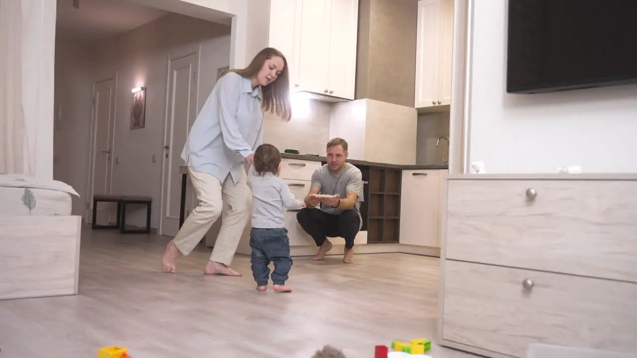 Madre Ayudando A Su Bebé A Dar Sus Primeros Pasos Hacia La Cocina