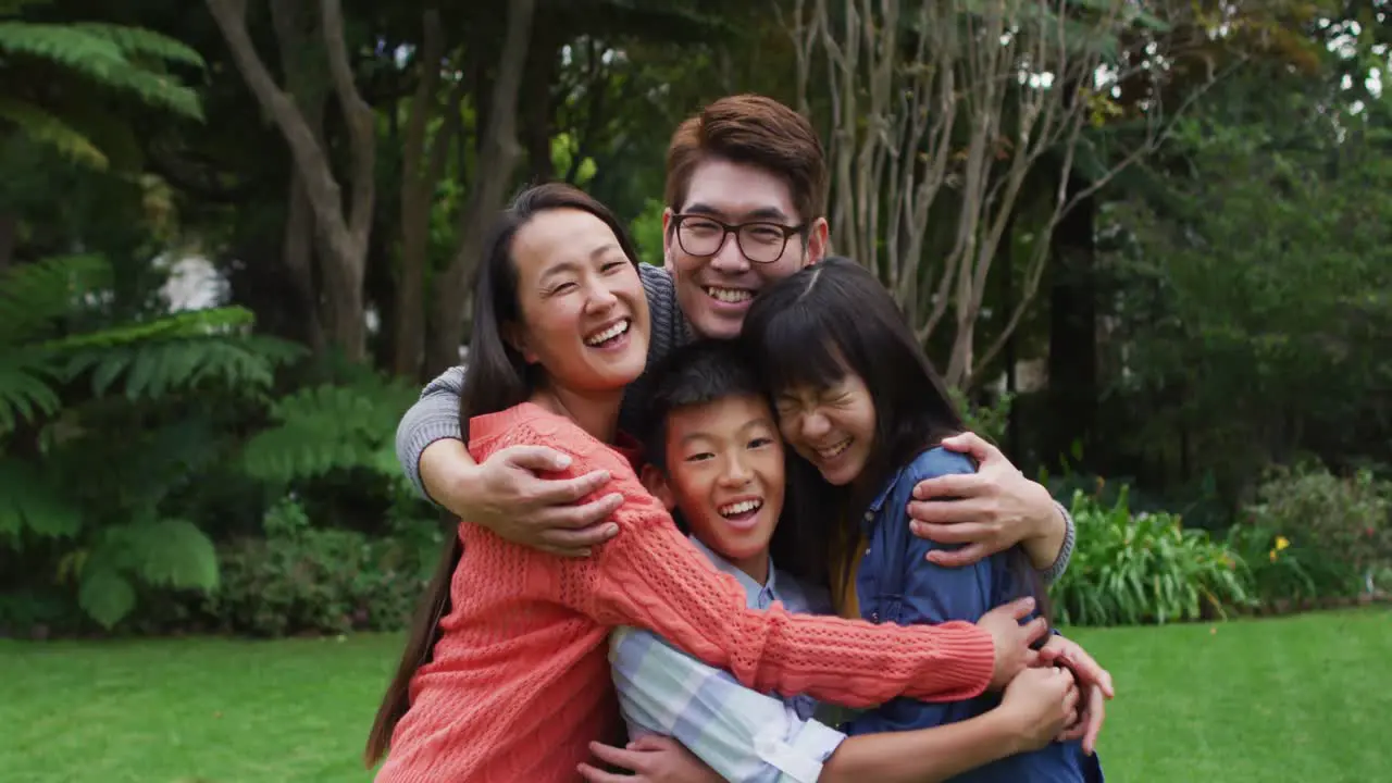 Padres Asiáticos Sonrientes Abrazando A Un Hijo E Hija Felices En El Jardín