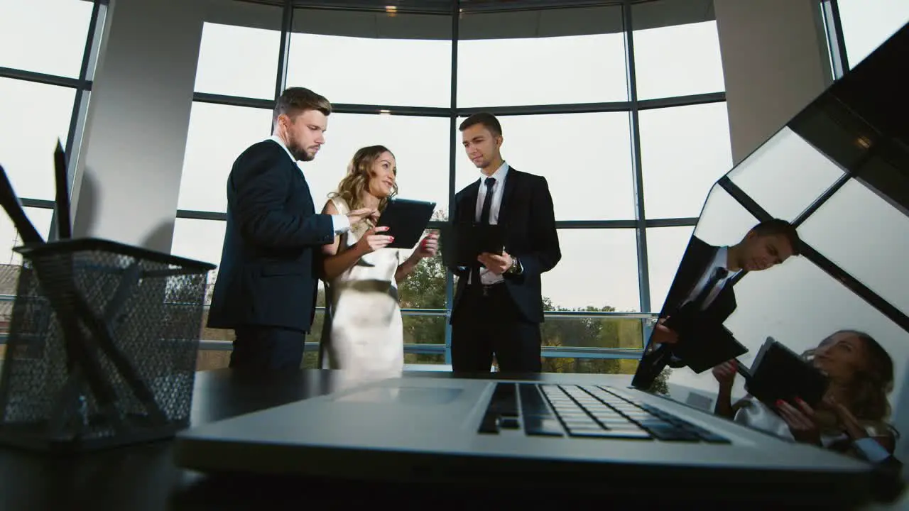 A group of businessmen discuss in the office