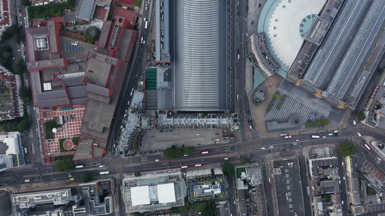 Aerial birds eye overhead top down view of traffic in streets Panning view of St Pancras train station and surrounding buildings London UK