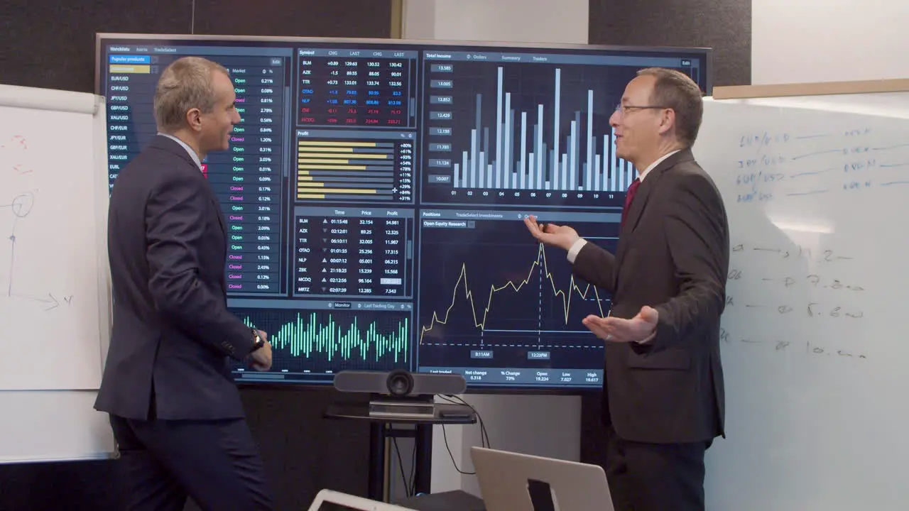 Men In Suits In Room With Big Digital Screen With Data