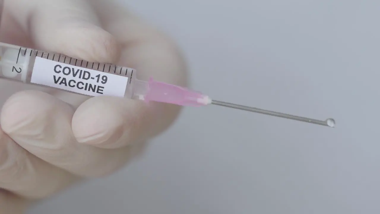 Fluid Drops Ejected From A Syringe Through Hypodermic Needle Covid-19 Vaccine close up