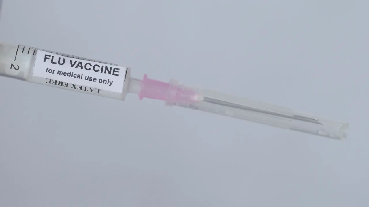 Medical Man Removing The Needle From Injection Filled With Flu Vaccine Close Up Shot