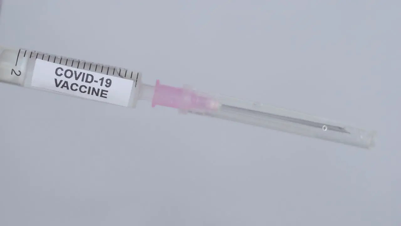 Hand With Glove Removing Needle From Syringe For Covid-19 Vaccine close up