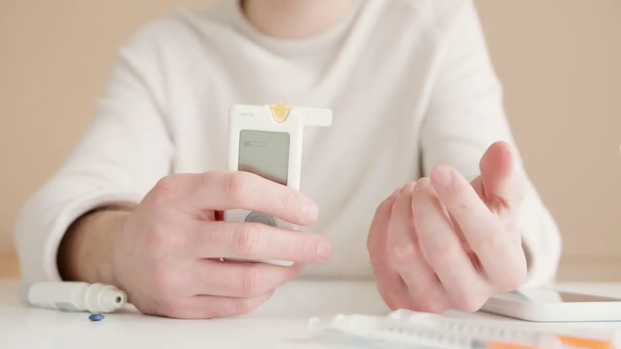 Diabetic woman using a glucose meter during a home blood glucose test checking blood sugar levels for diabetes