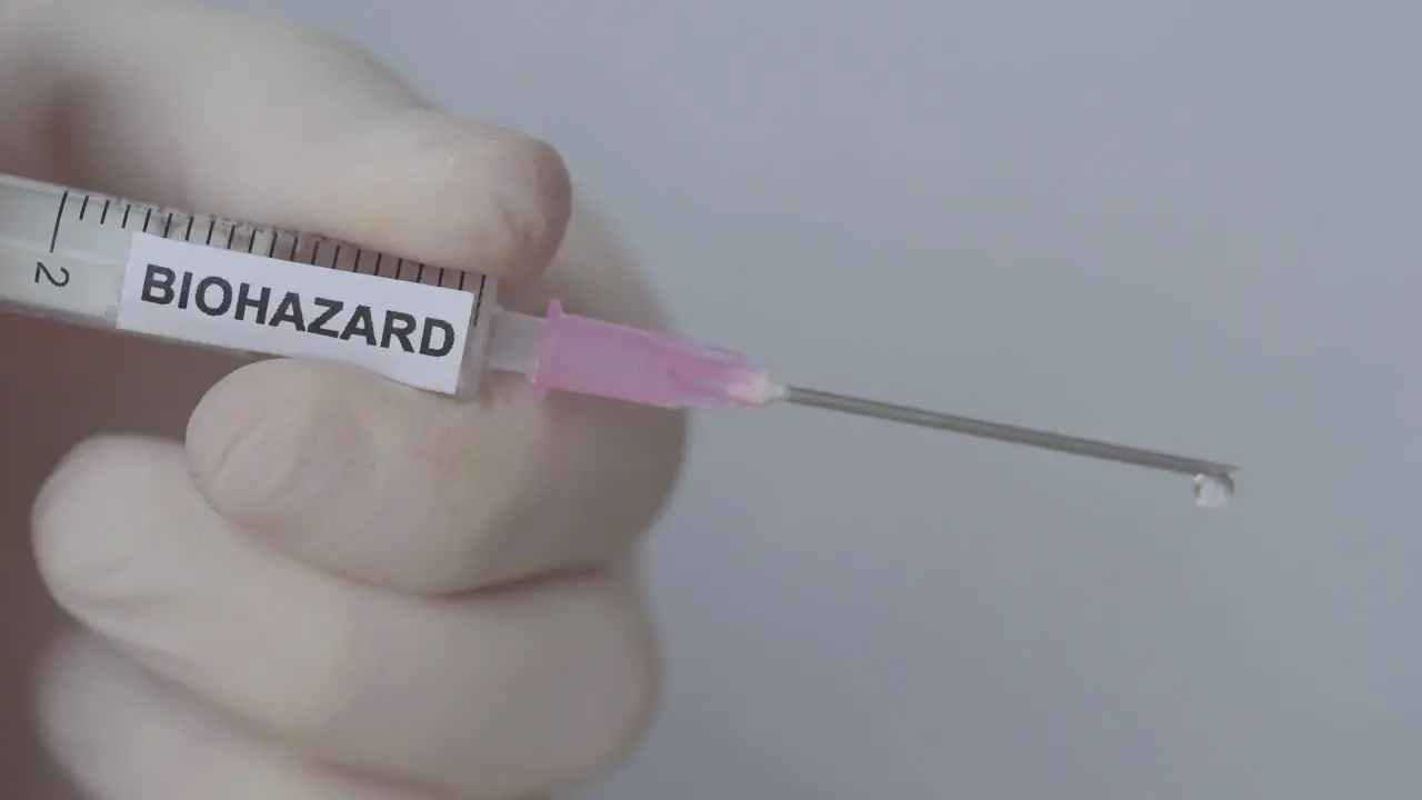 Medic Wearing Glove Carefully Push The Syringe Releasing Fluid Drops Close Up Shot