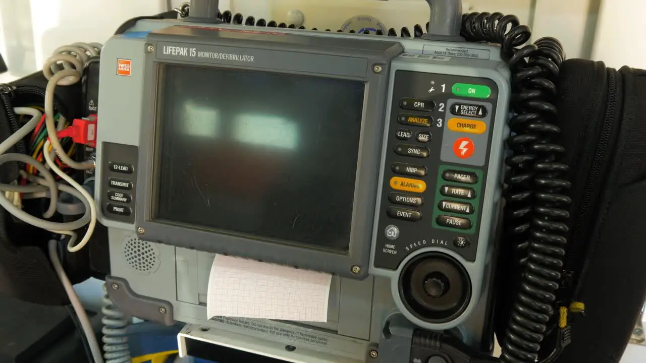 Portable defibrillator emergency medical service vehicle equipment screen turned off handheld medium closeup shot