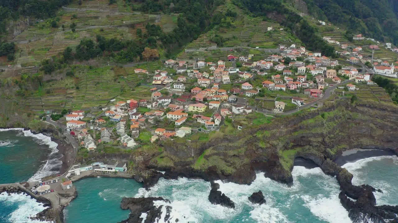 Seixal Madeira Coastline drone shot with waves mountains in clouds Panoramic Ocean Horizon with cliffs