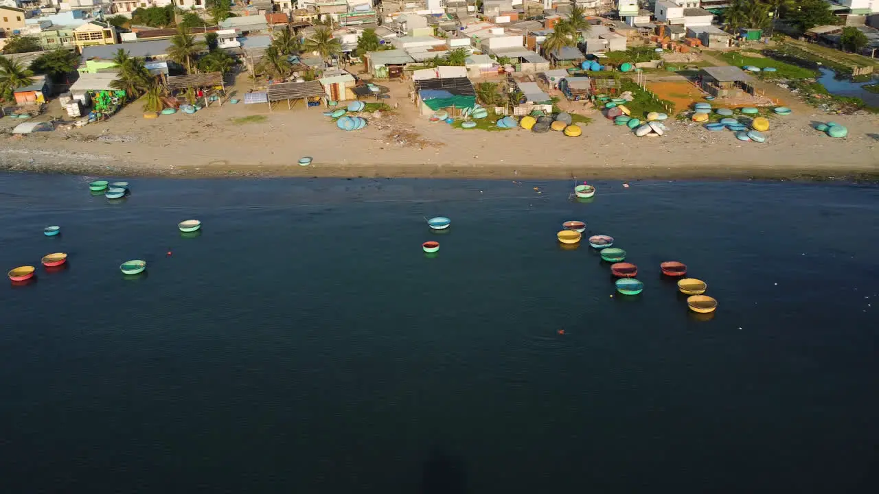 Aerial round Vietnamese coracle fishing boats moored by shore of fishing village in Southeast Asia