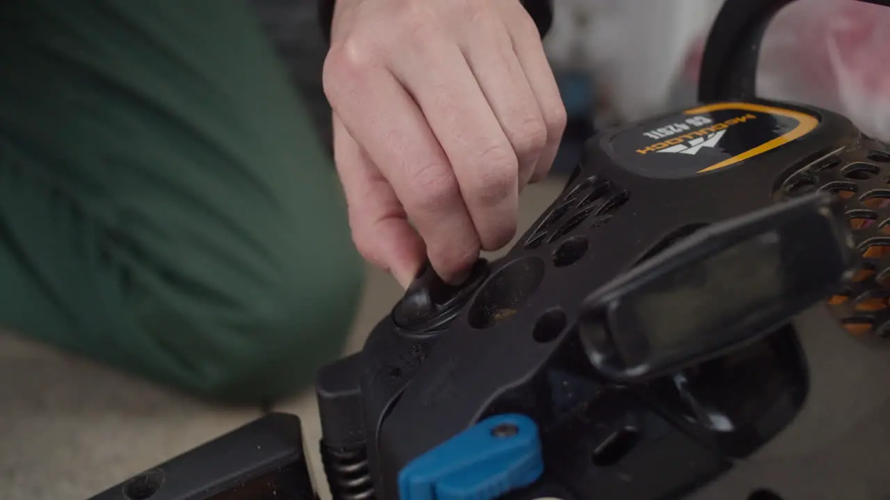 Close up shot of female caucasian hand screwing a cap onto a chainsaw