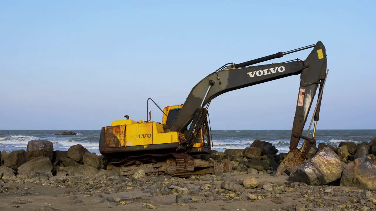 Abandoned Yellow Digger on a Rocky Beach in Thailand