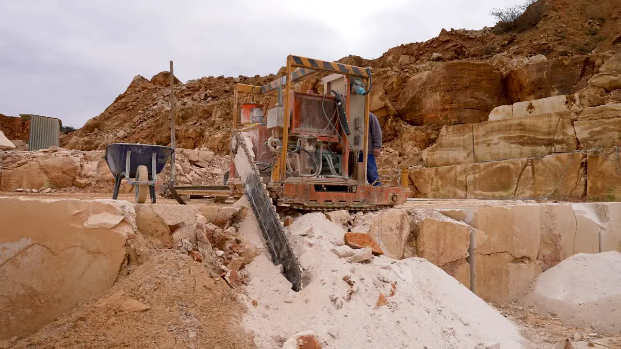 Stone diesel Chainsaw machine cutting blocks of limestone at a quarry Locked medium shot