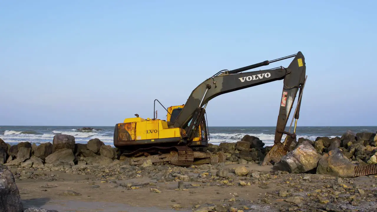 Abandoned Yellow Digging Machinery on Rocky Beach Thailand