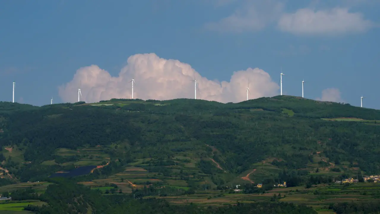 Drone footage of large electric windmill on top of a hill