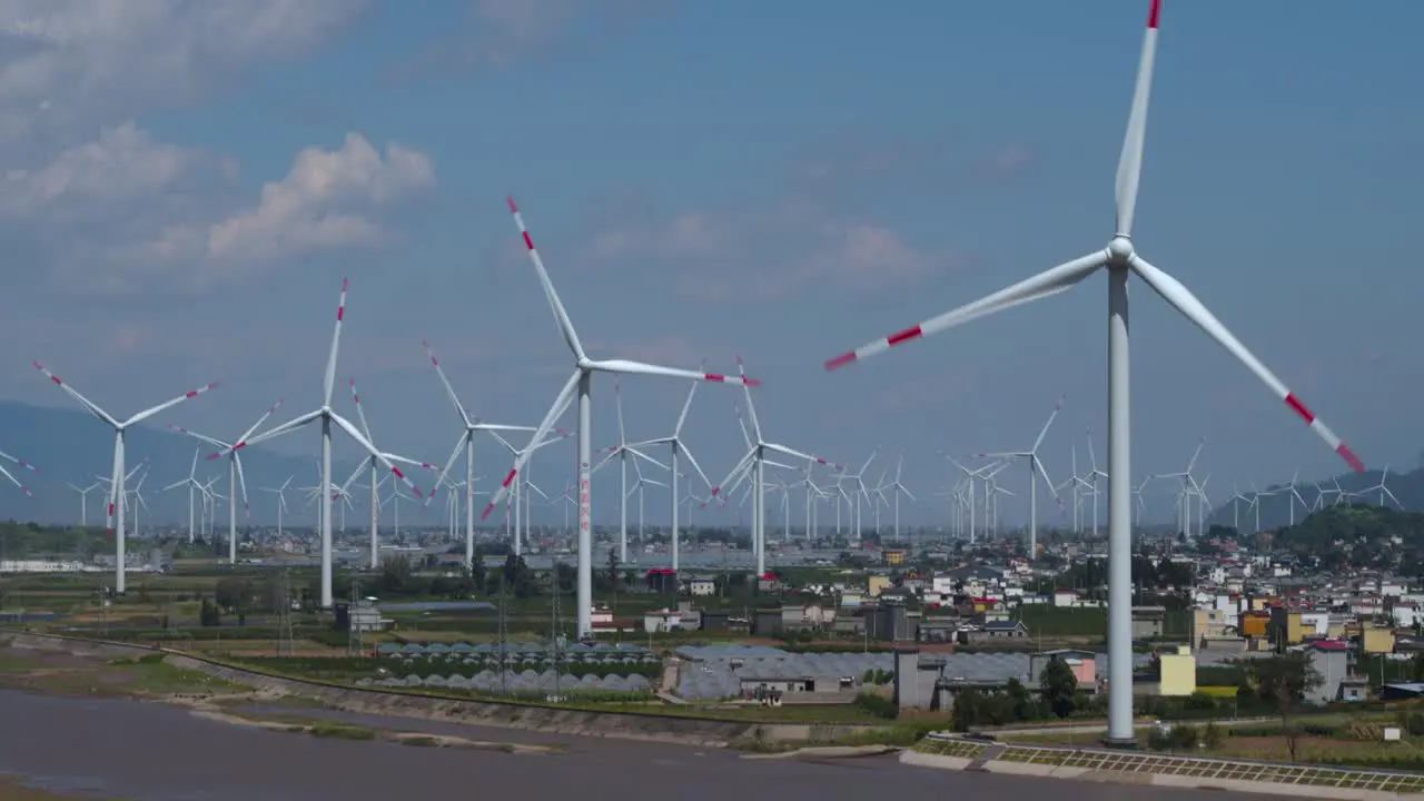 Drone footage of large electric windmill in a flat basin