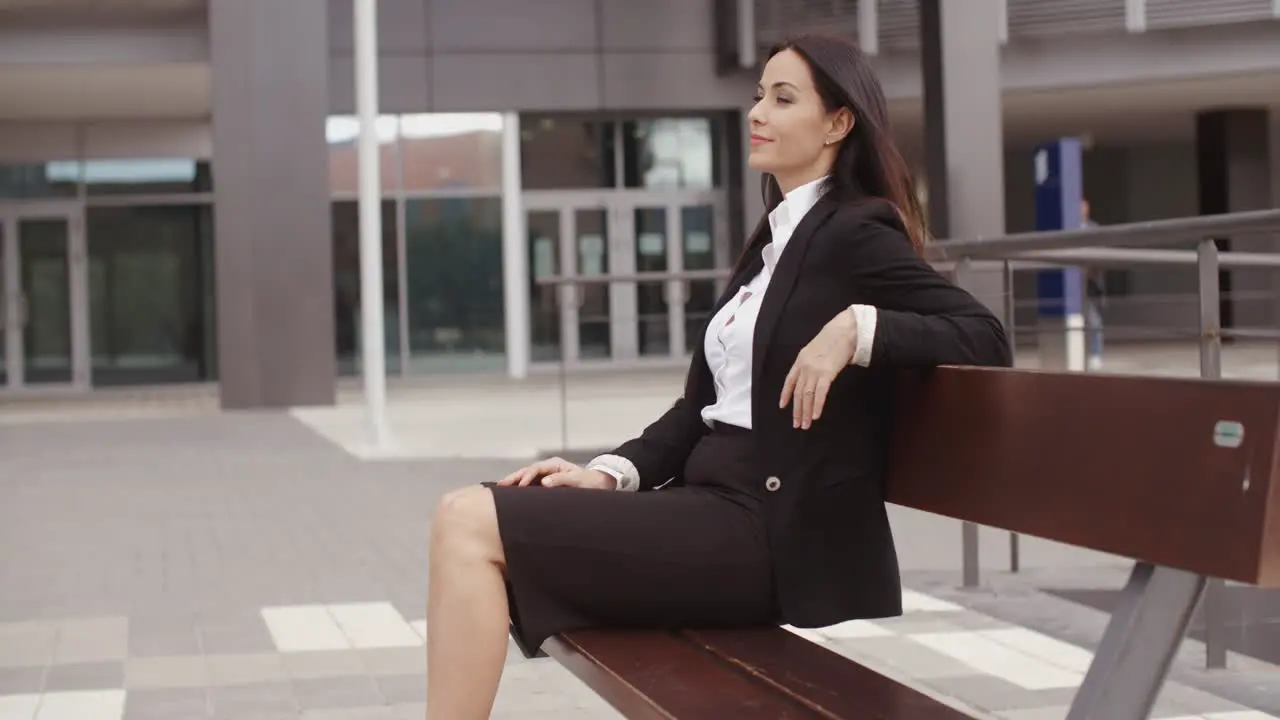 Calm business woman sitting outdoors