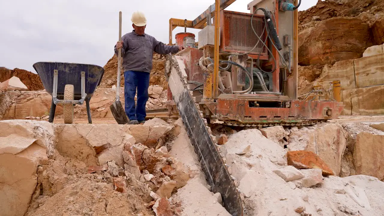 Stone Chainsaw machine cutting blocks of limestone at a quarry with operator Medium shot