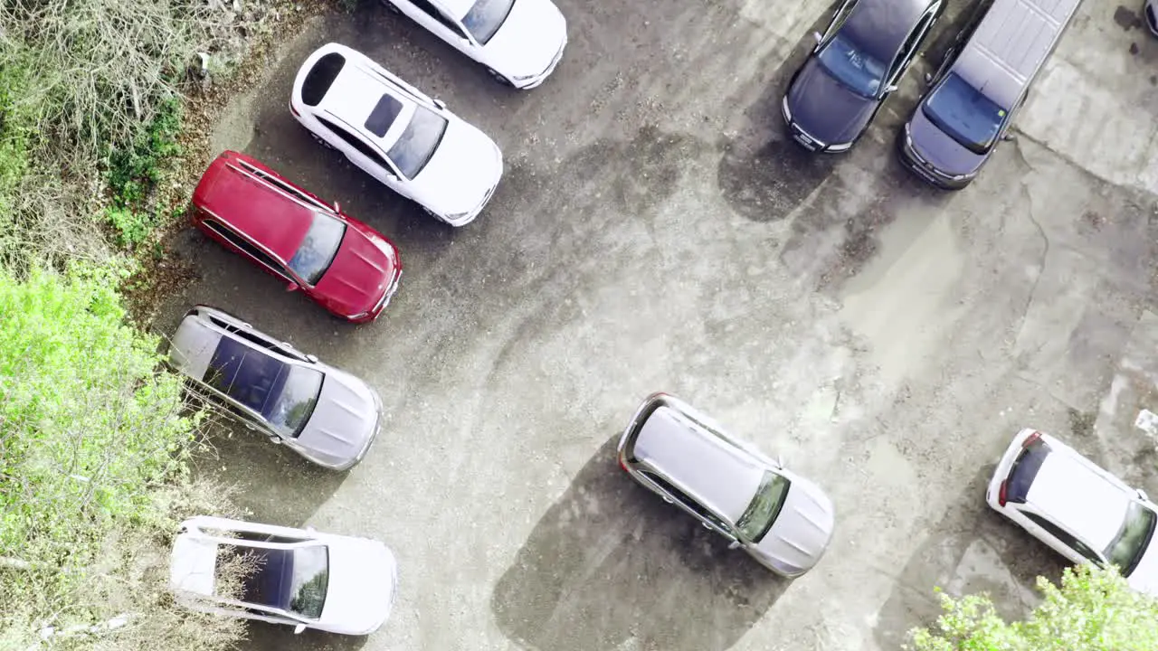 Bird's eye view of car dealership parking lot in a sunny morning Aerial descending Rocket shot