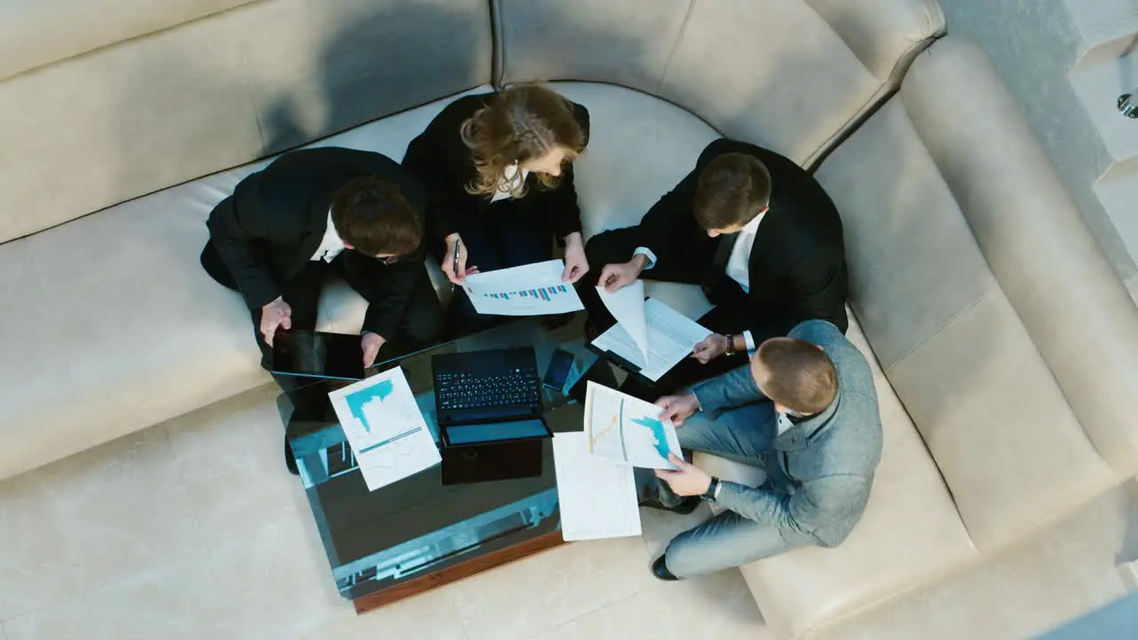 A group of businessmen goes into the lobby of the hotel