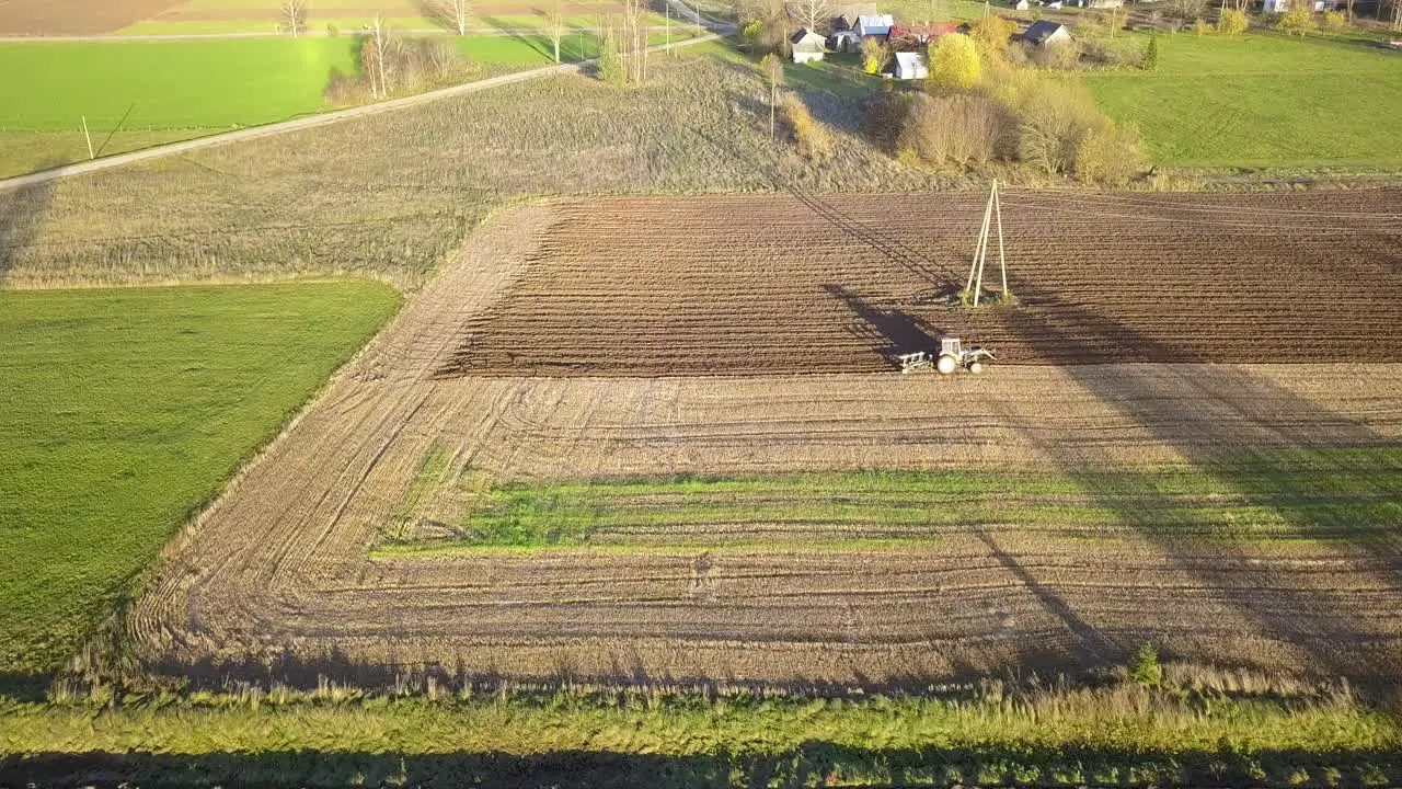 Hard Working Farmer using Tractor to Plow Fields for Crop season