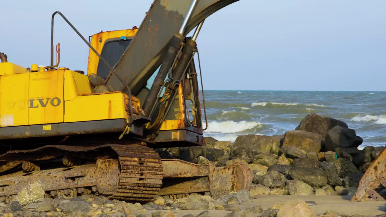 Abandoned Digger Stuck on Rocks at Beach in Thailand