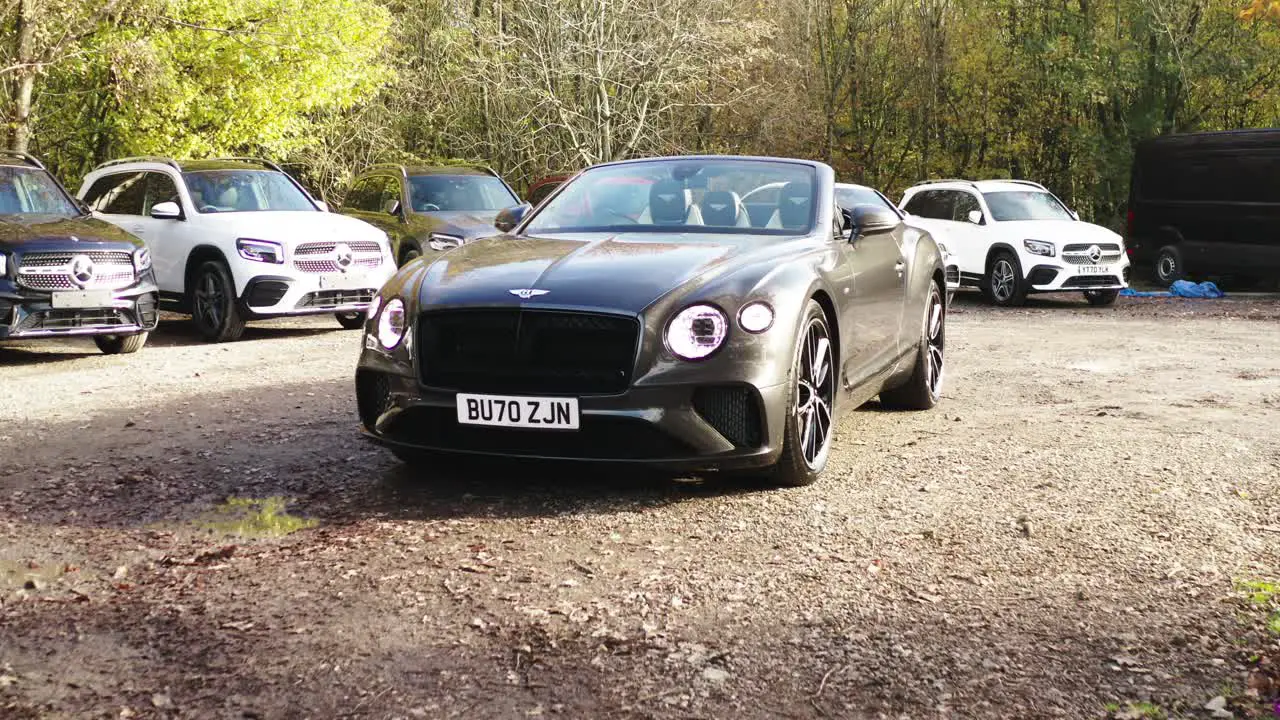 Bentley Continental GT car in a car dealership parking lot on a sunny morning Push in wide shot