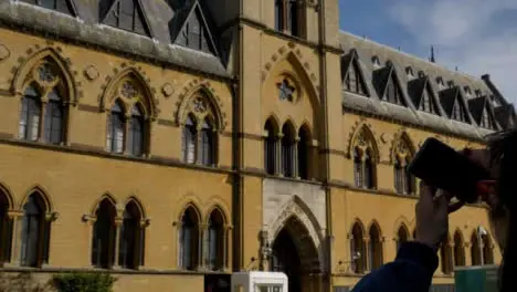 Tracking Shot Past Young Woman Taking Photo of Oxford University Museum of Natural History