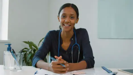 Happy Young Female Doctor Listening During Video Meeting