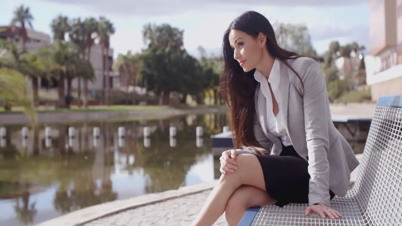 Business woman sitting on bench looking away