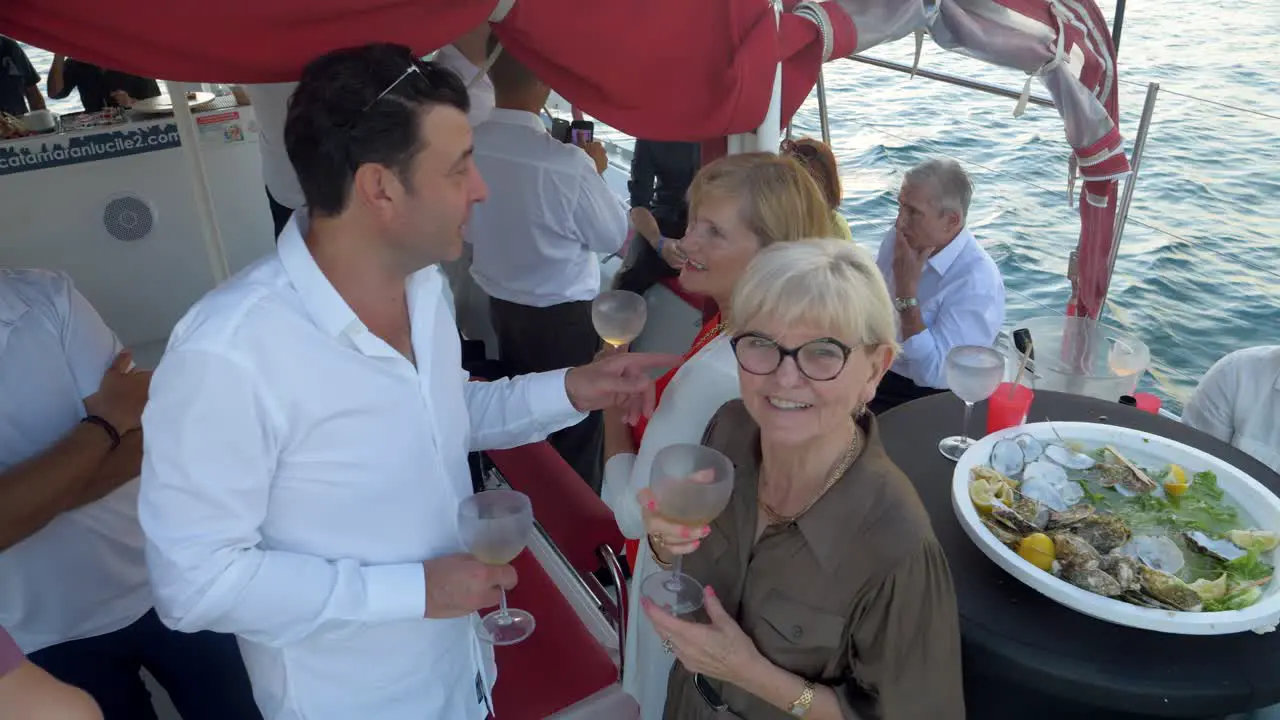 Guests on a wedding party at sea enjoying themselves with champagne and sea food