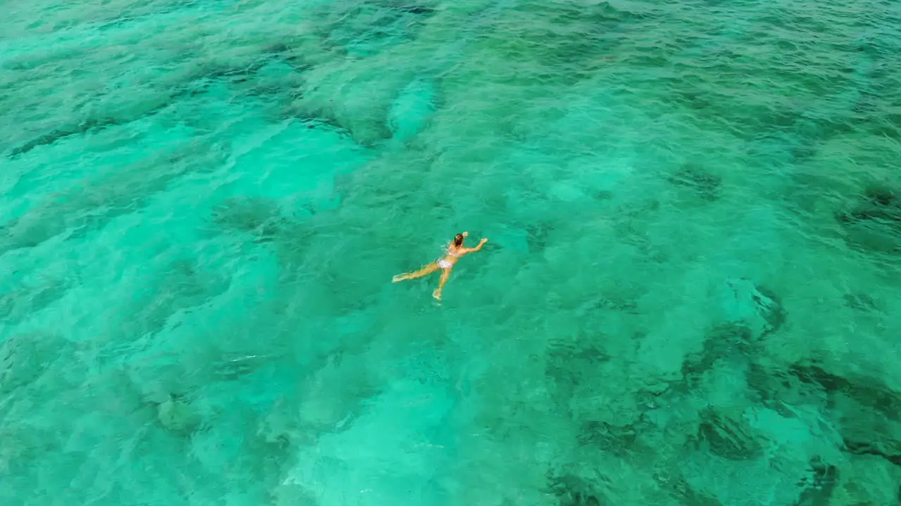 Girl swimming in the clear waters of the Bali Sea on a hot sunny day