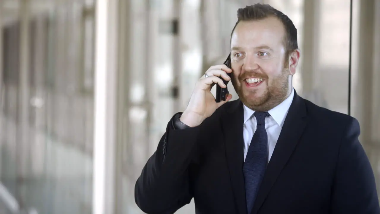 A businessman receives good news as he uses his cell phone