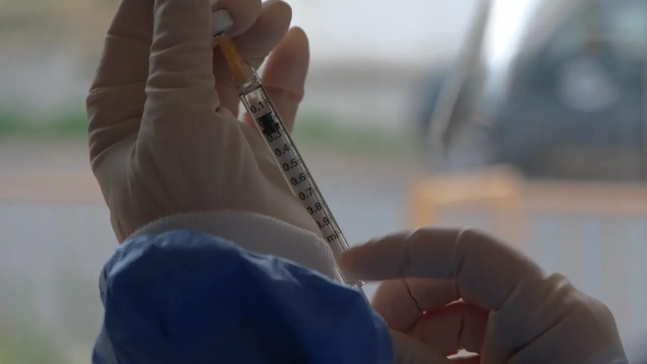 Close-up of measuring out a dose of an injectable vaccine