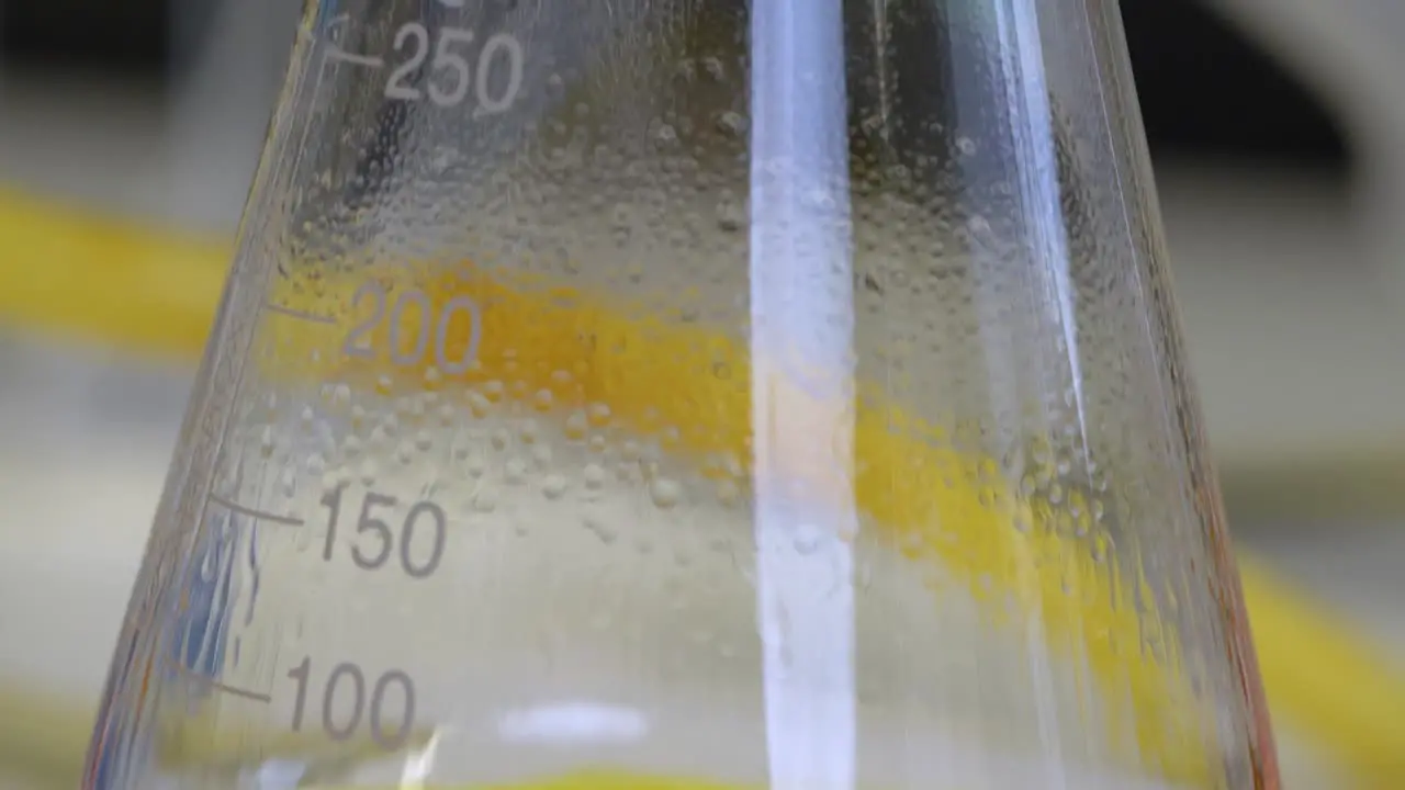 Close-up of a chemistry distillation dripping into a beaker