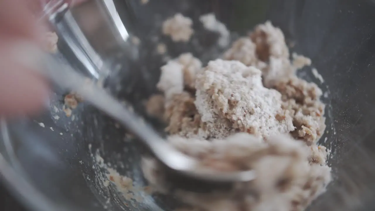 White Powder is mixed with a spoon with mixed food on a kitchen countertop