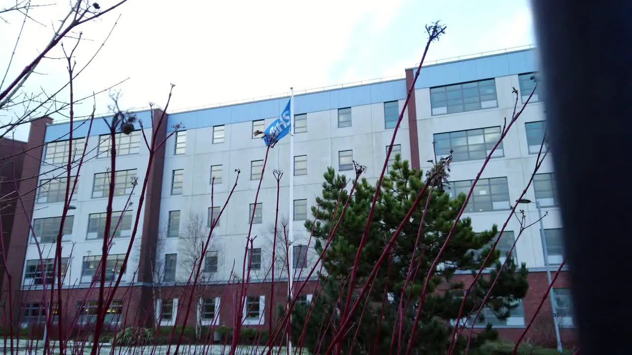 NHS flag waves proudly outside a snowy hospital symbolizing the strength and resilience of the UK's healthcare system